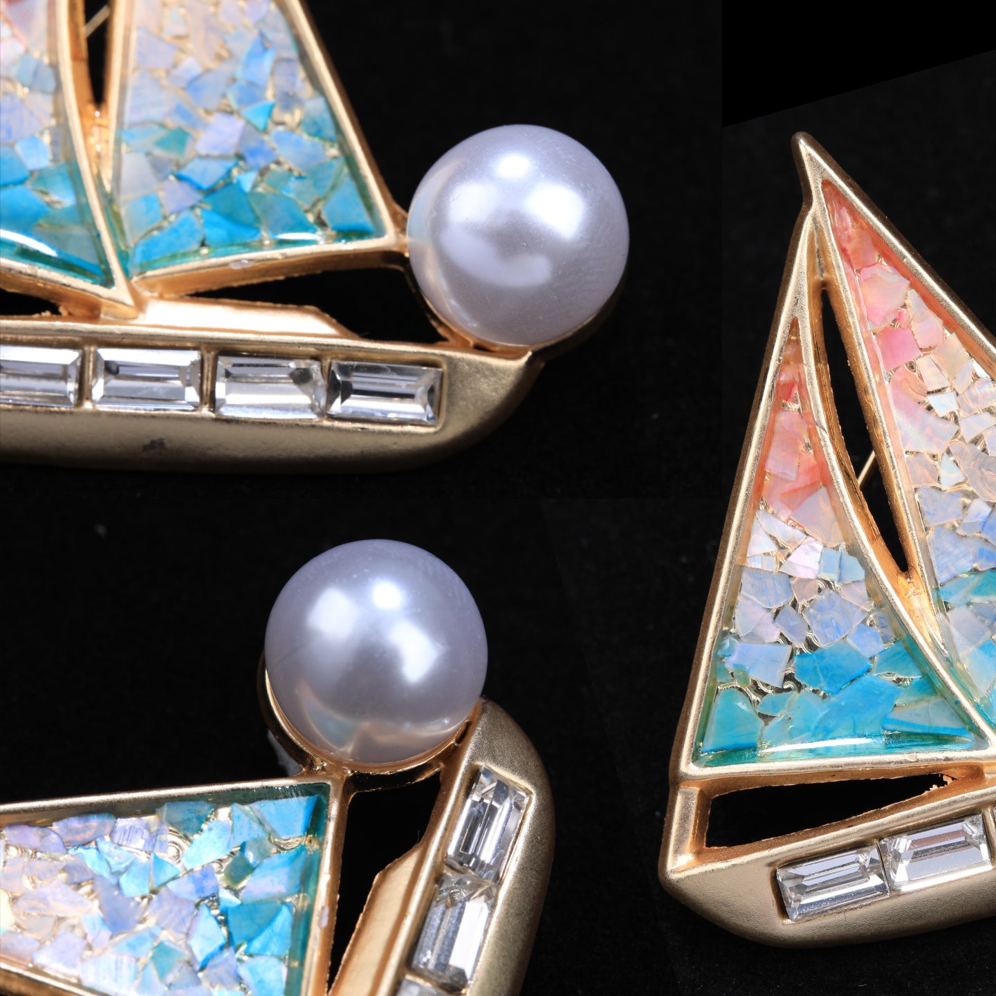 Close up of mother of pearl,nacre shell brooch＆sailboat brooch on black