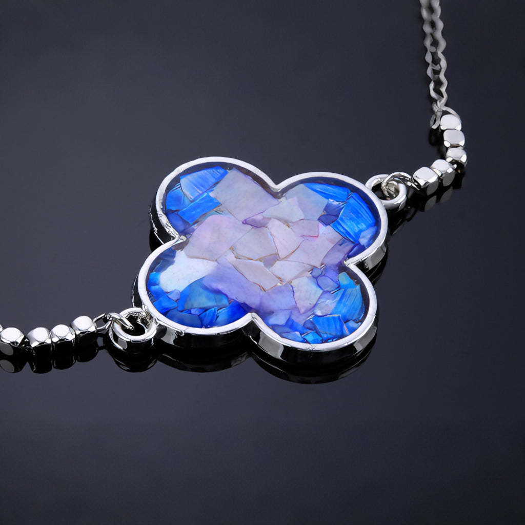 Woman wearing dainty clover mother-of-pearl bracelet on wrist 