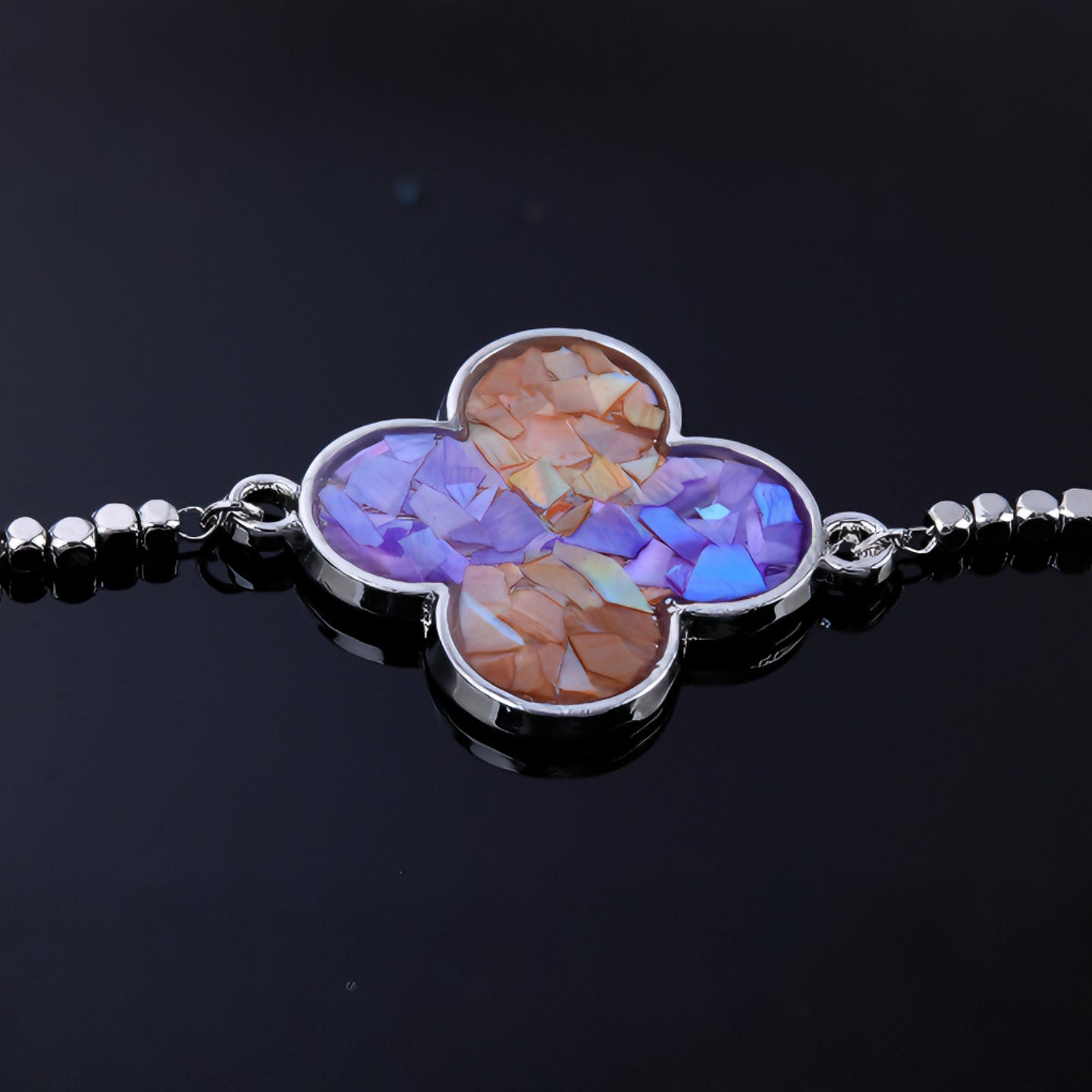 Woman wearing dainty clover mother-of-pearl bracelet on wrist  