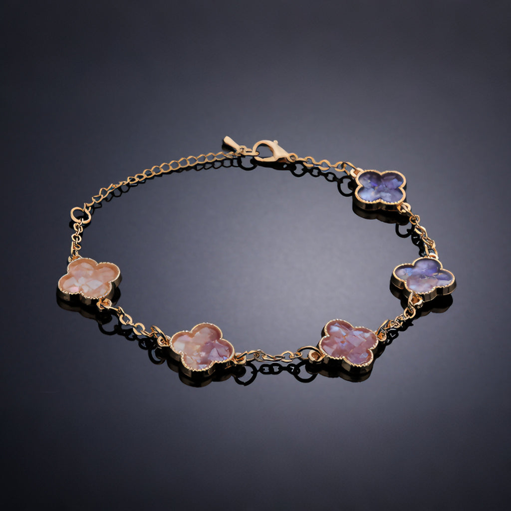 Close-up of gradient mother-of-pearl clover link—hand-placed shell fragments in gold setting  