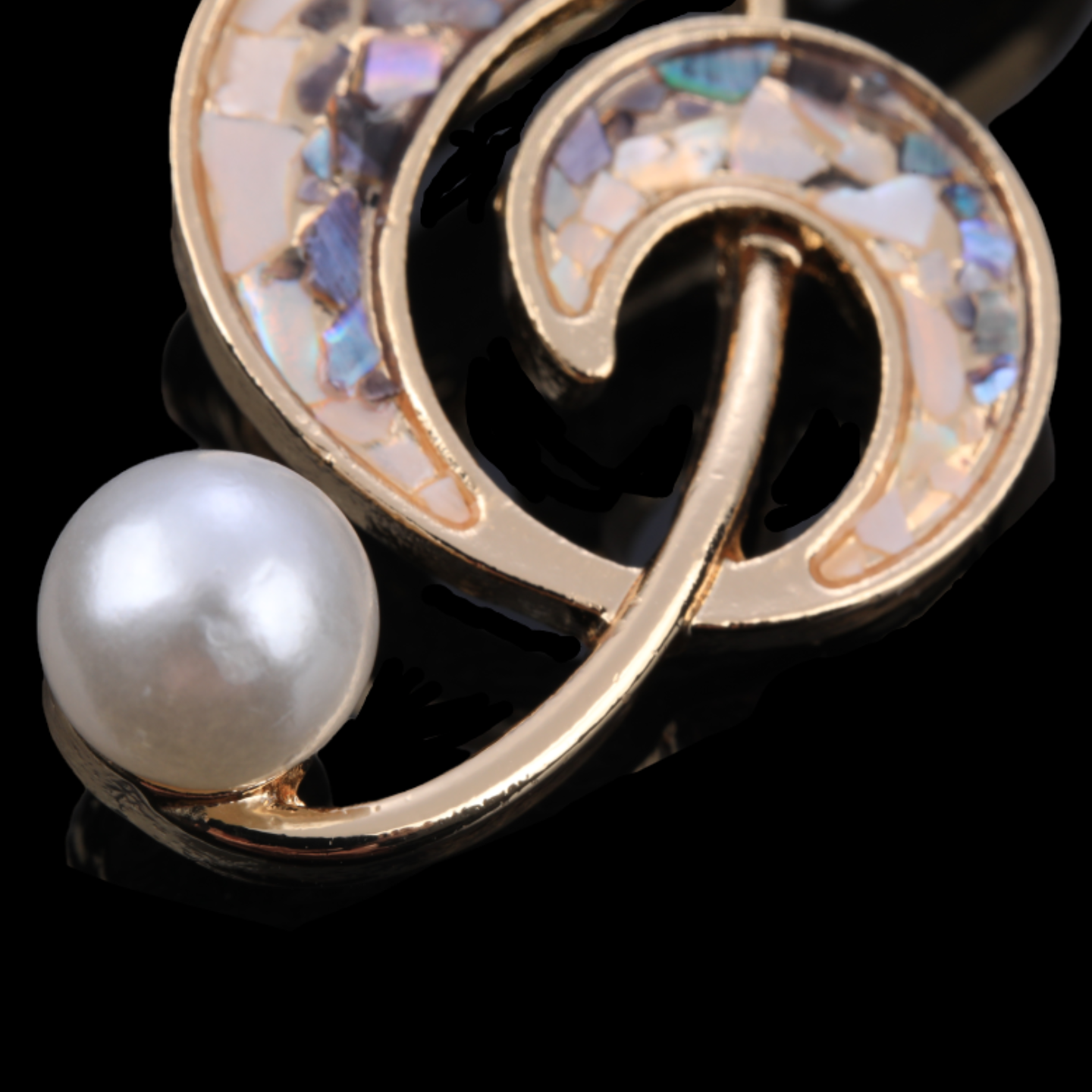 Close up of Handmade iridescent treble clef mother-of-pearl brooch,nacre shell brooch