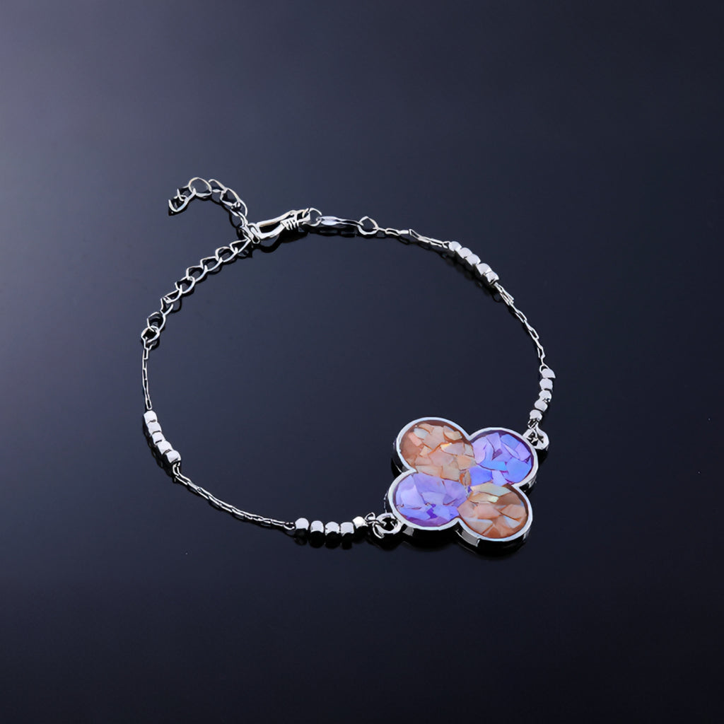 Close-up of clover charm with hand-placed blue purple mother-of-pearl fragments  