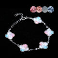 Clover mother of pearl bracelet with pink-blue gradient charms on display  