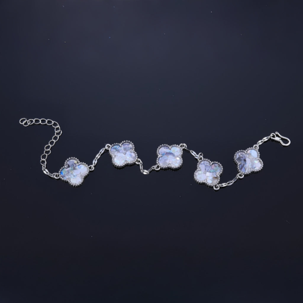 Silver alloy frame around mother of pearl clover fragment  