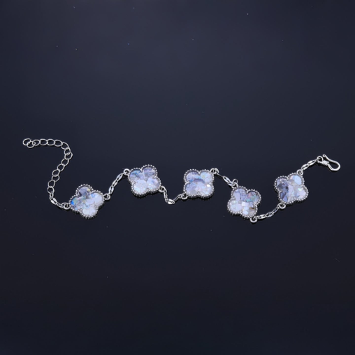Silver alloy frame around mother of pearl clover fragment  